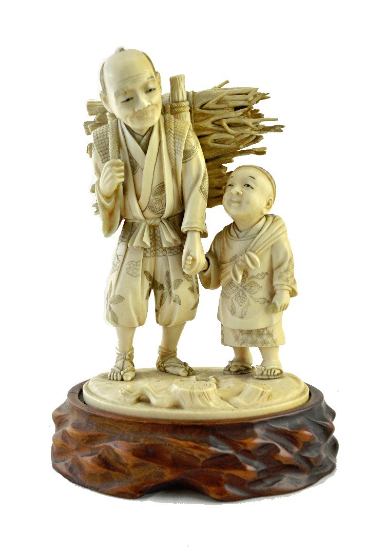 Appraisal: A Japanese ivory okimono of a man and child Meiji