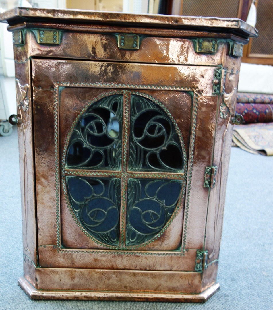 Appraisal: A Liberty's retailed copper and brass veneered hanging corner cupboard