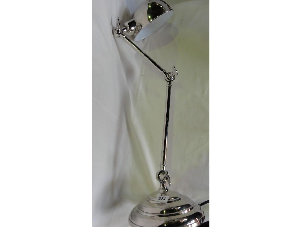 Appraisal: An adjustable silver plated desk light raised on a circular