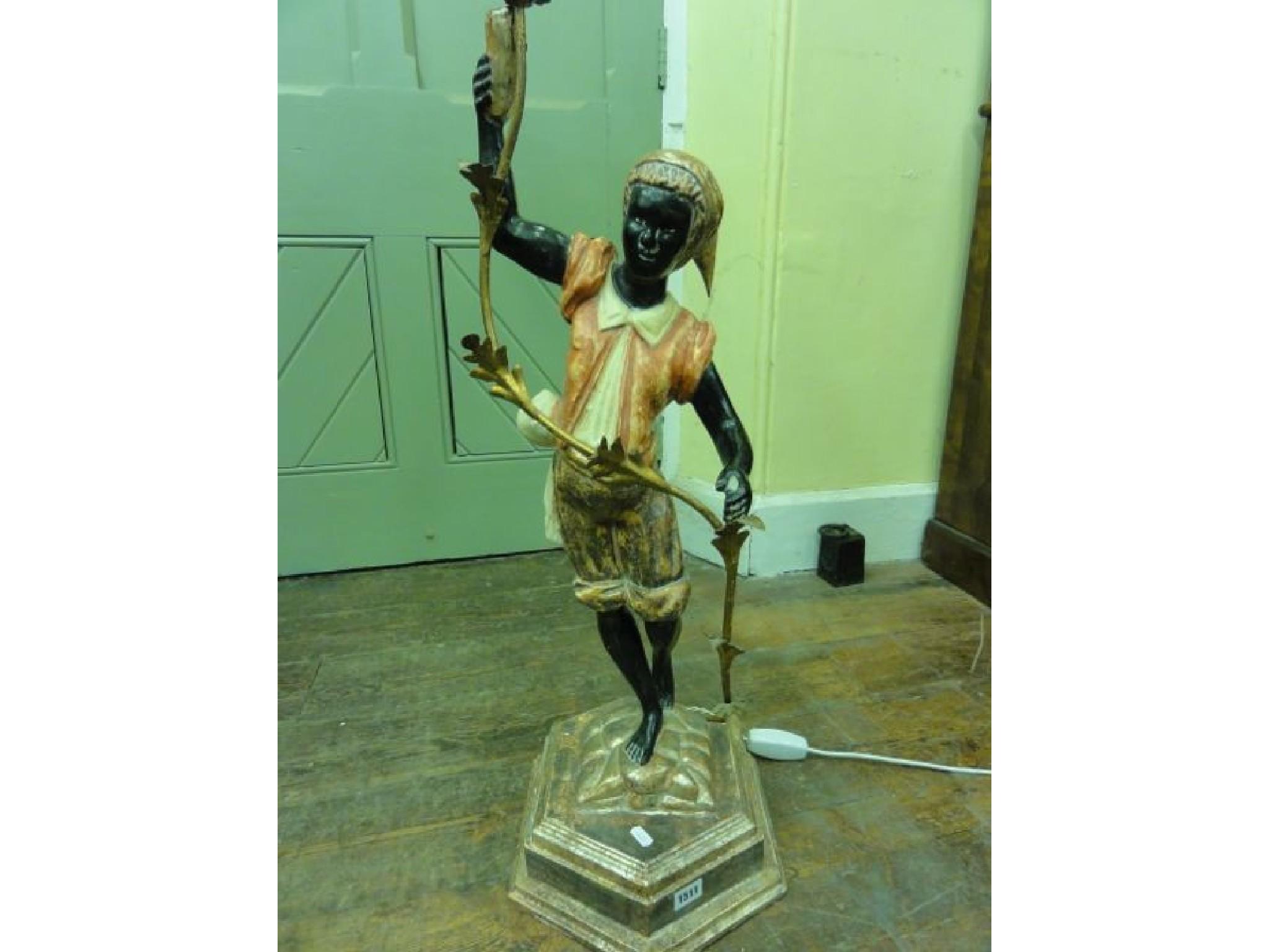 Appraisal: A Blackamoor candelabra the table standing model depicting a turban