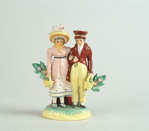 Appraisal: STAFFORDSHIRE FIGURAL GROUP OF MAN AND WOMAN Figurine shows woman