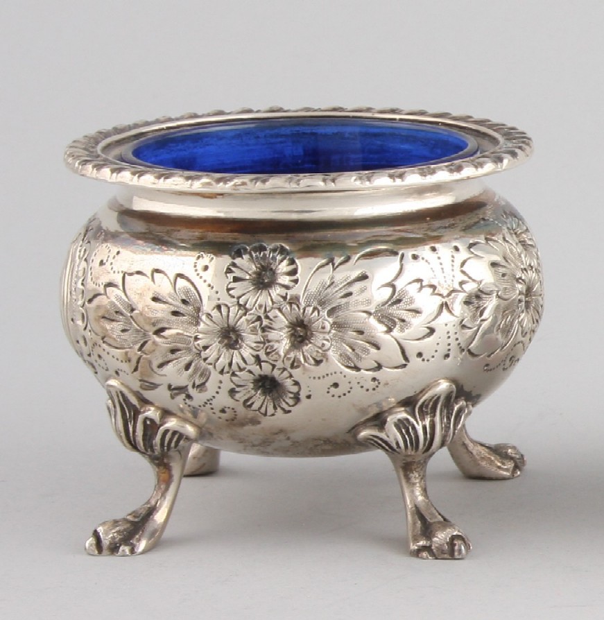 Appraisal: Repousse flowers and paired C-scroll cartouche gadrooned rim bird-like feet