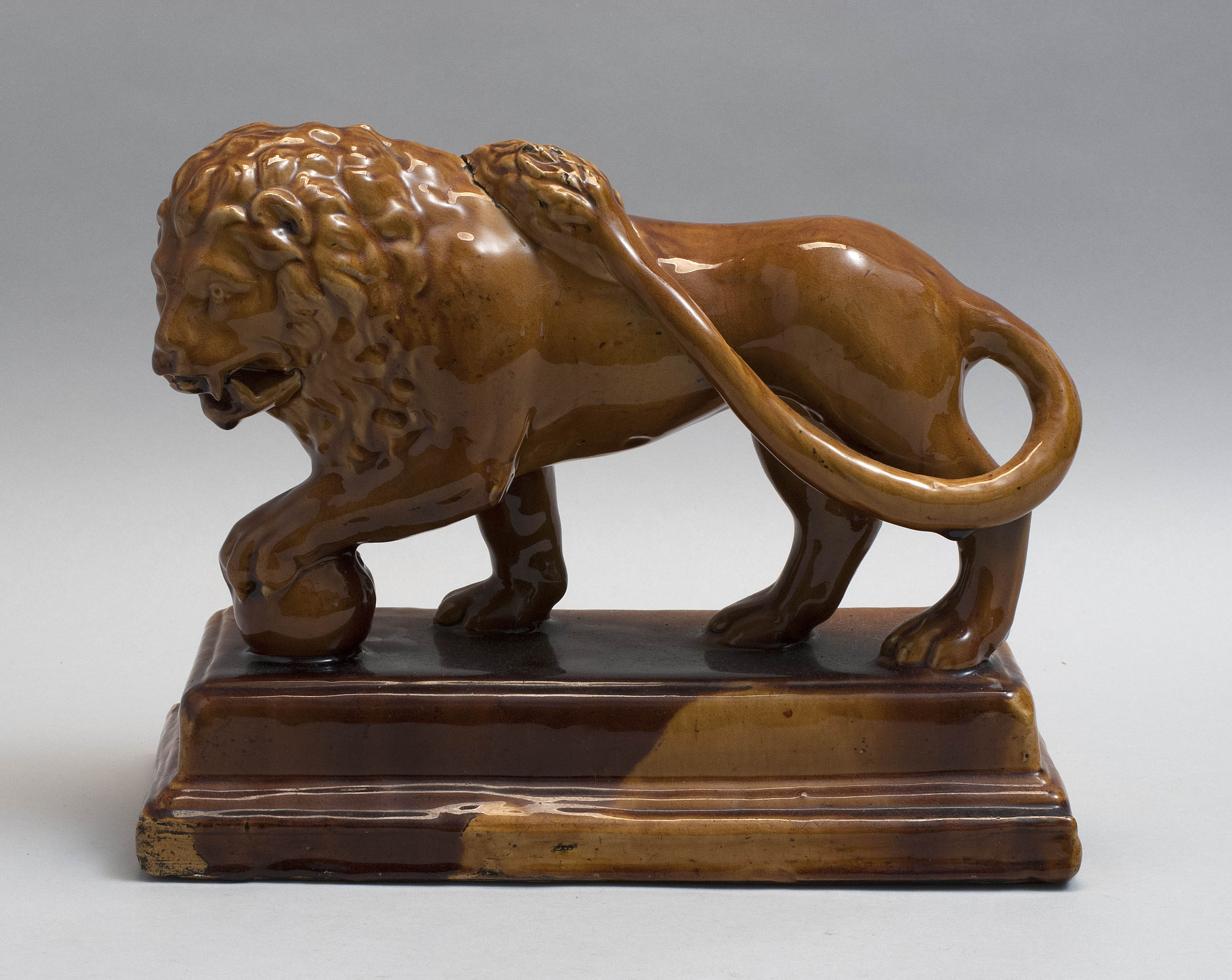 Appraisal: ROCKINGHAM OR TREACLE-GLAZED YELLOWWARE FIGURE OF A LION England th