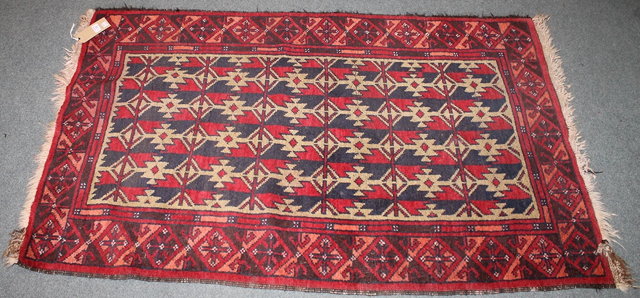 Appraisal: AN AFGHAN RED GROUND RUG with central geometric panel and