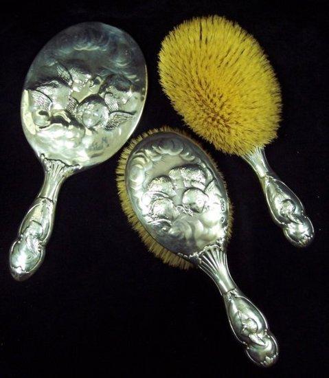 Appraisal: A silver backed hand mirror London with two matching hairbrushes