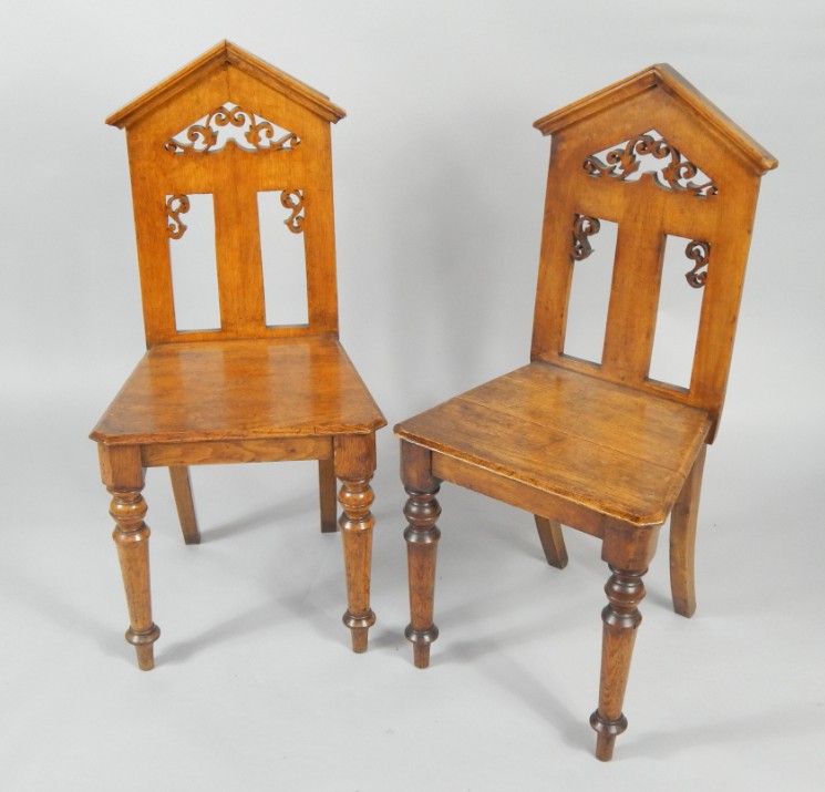 Appraisal: A pair of Victorian Gothic oak hall chairs with pierced