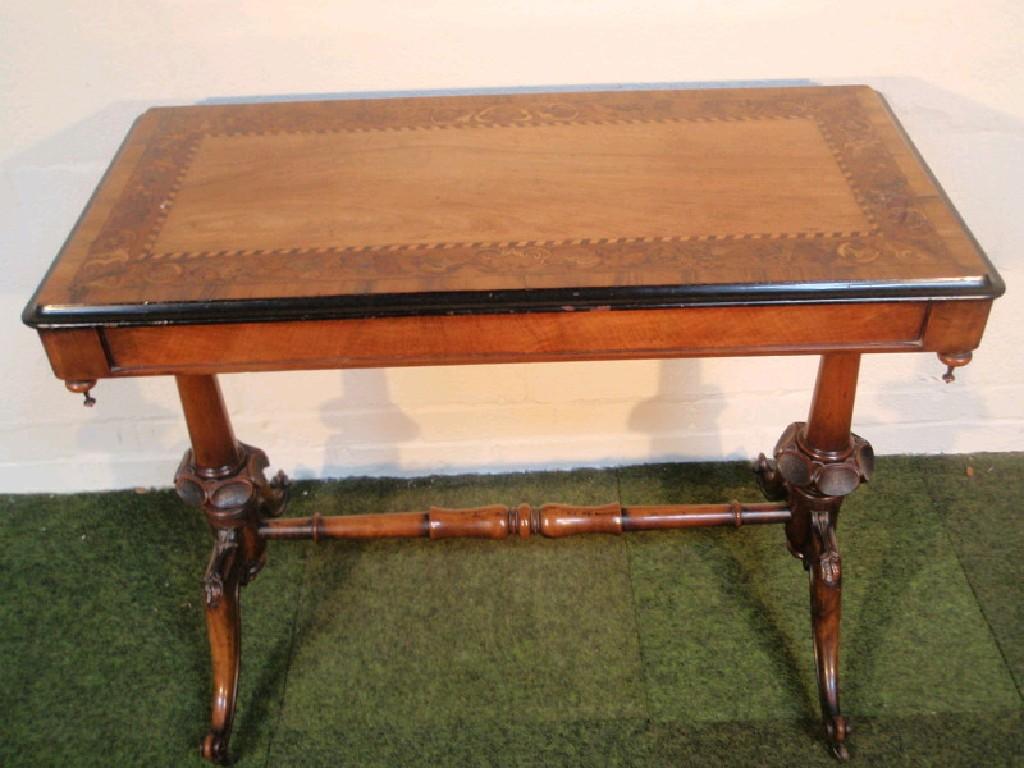 Appraisal: A Victorian walnut marquetry centre table with cross-banded top carved