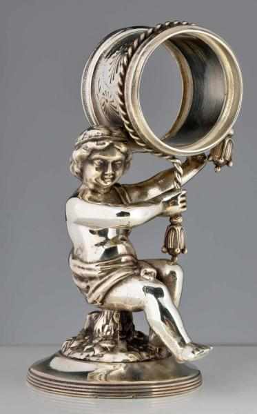 Appraisal: Draped Cherub Figural Napkin Ring Cherub balances napkin holder on