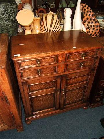 Appraisal: An oak canteen cabinet with the lifting lid opening to