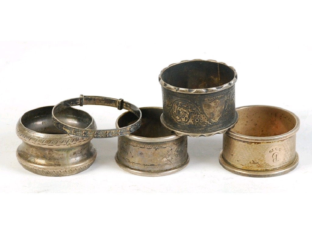 Appraisal: FOUR VARIOUS SILVER CIRCULAR NAPKIN RINGS AND A CHILD'S BANGLE