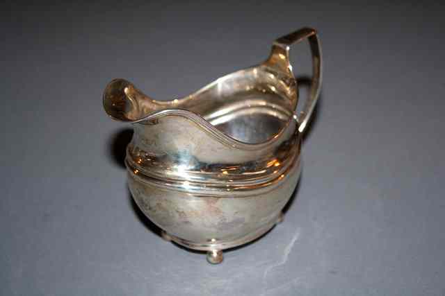 Appraisal: A GEORGE III SILVER CREAM JUG helmet shaped with reeded