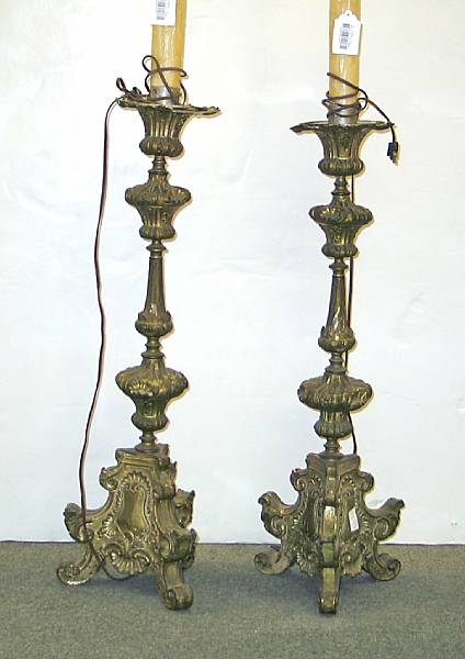 Appraisal: A pair of Baroque style brass repousse clad floor prickets