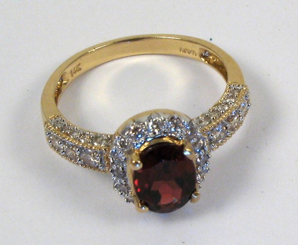 Appraisal: GARNET AND FOURTEEN KARAT GOLD RING centering an oval-cut garnet