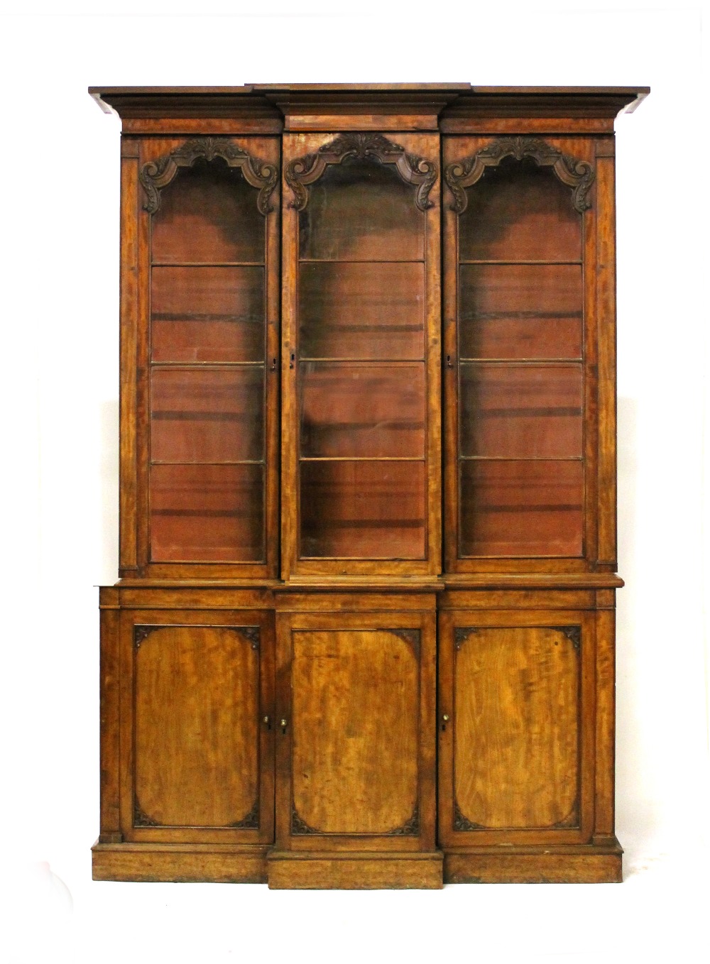 Appraisal: An early Victorian mahogany triple section breakfront bookcase cupboard with