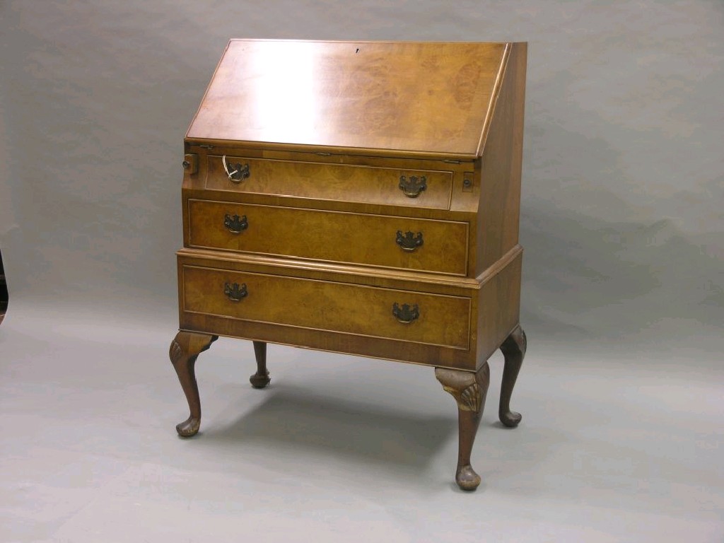 Appraisal: A walnut bureau burr veneered cross-banded top enclosing fittings above