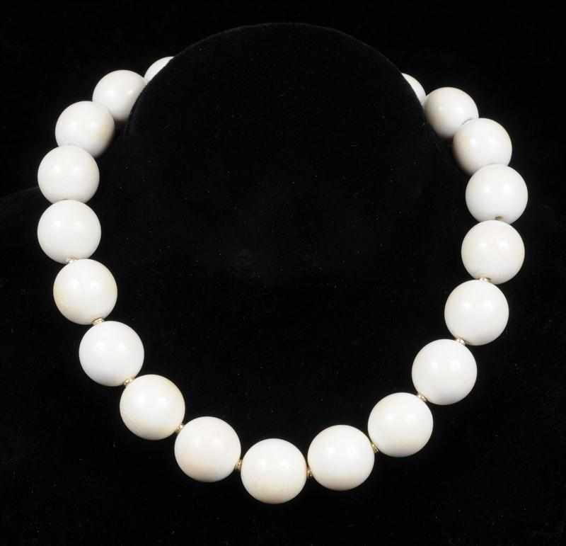 Appraisal: IVORY BEAD AND RING SET The necklace with coral disc