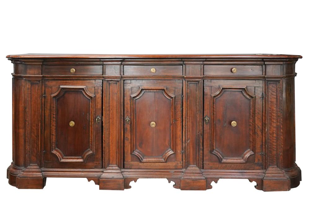 Appraisal: TUSCAN-STYLE WALNUT SIDEBOARDthe shaped rectangular top above three frieze drawers