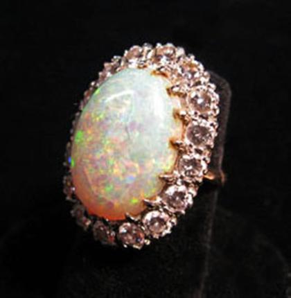 Appraisal: Opal and diamond dinner ring Large oval opal framed by