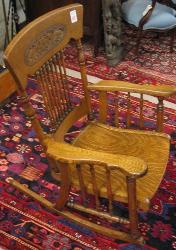 Appraisal: AN OAK SPINDLE-BACK ROCKING ARMCHAIR American late th century having