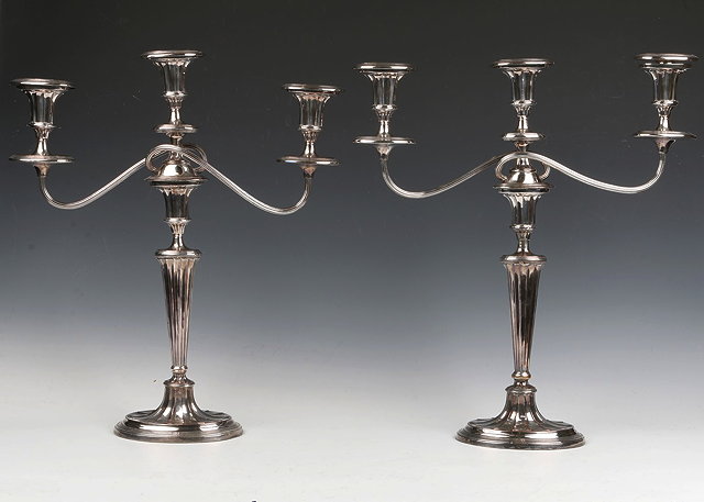 Appraisal: A PAIR OF SILVER PLATED TWO BRANCH THREE LIGHT CANDELABRA