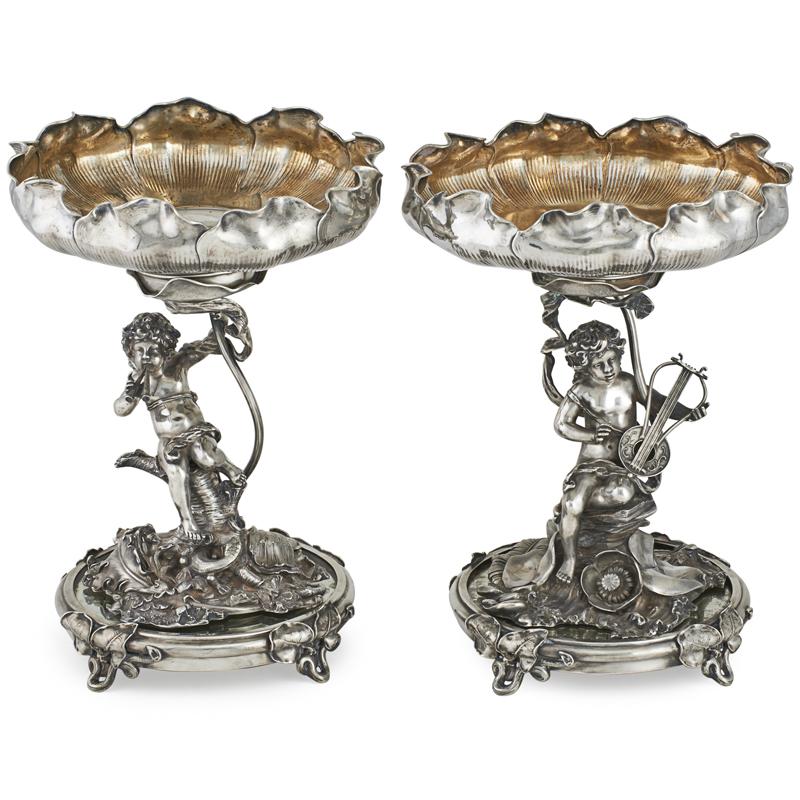 Appraisal: PAIR OF GERMAN SILVER COMPOTES Figural stands of cherubs amongst