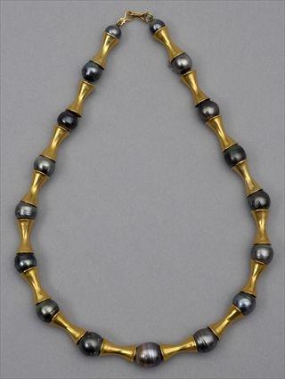 Appraisal: GOLD AND BLACK PEARL NECKLACE Strand of double funnel shaped