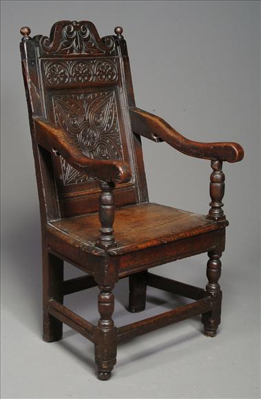 Appraisal: An oak open arm chair with carved back