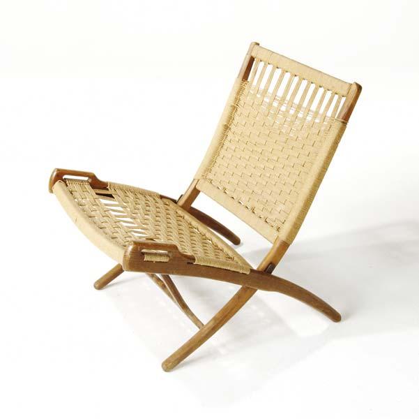 Appraisal: STYLE OF HANS WEGNER Walnut folding lounge chair with woven