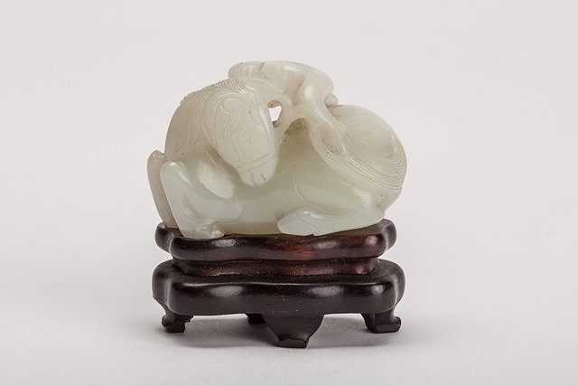 Appraisal: A CHINESE MUTTON FAT JADE PEBBLE carved as a reclining