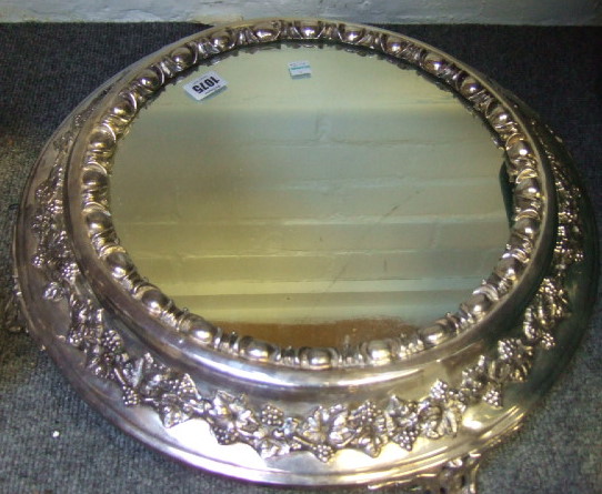 Appraisal: A plated metal mounted circular mirror plateau decorated with a