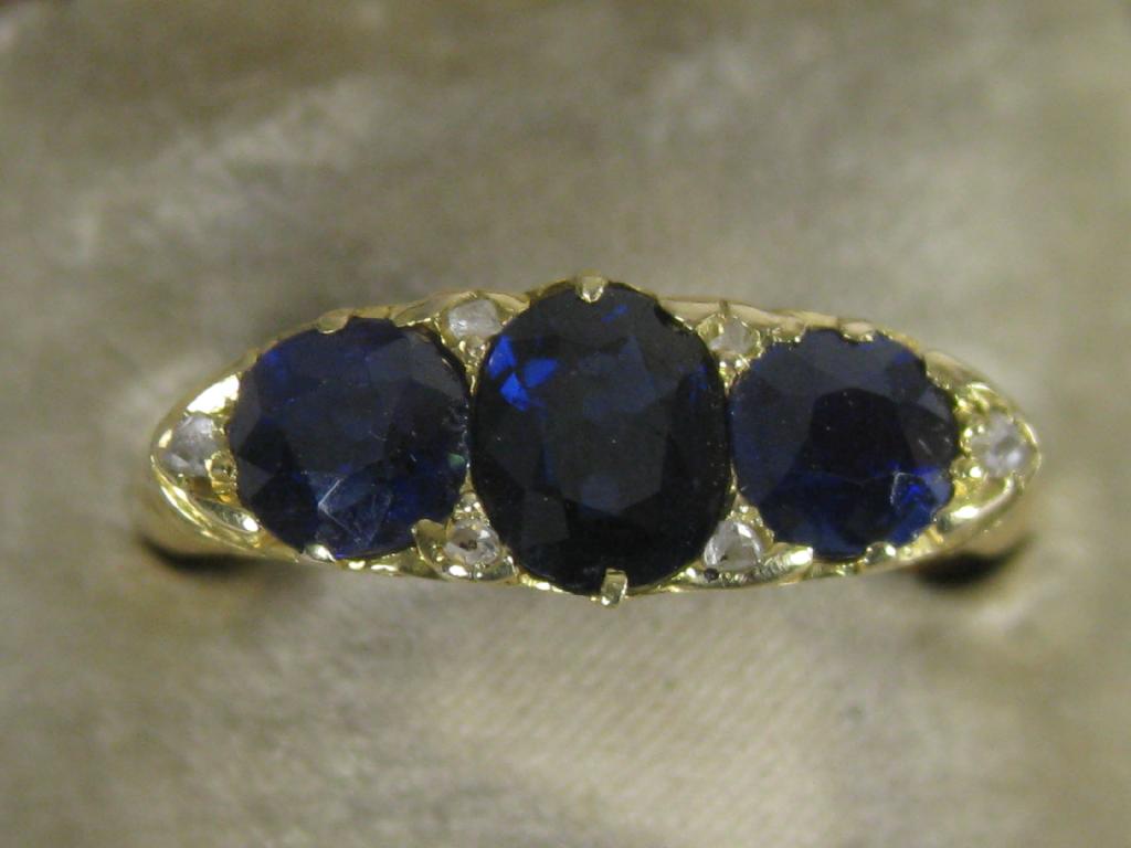 Appraisal: A three stone Sapphire Ring the central oval shape stone