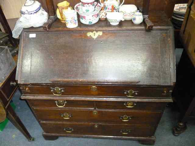 Appraisal: AN ANTIQUE OAK BUREAU the fall front enclosing a fitted