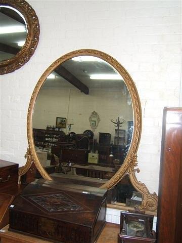 Appraisal: An antique oval gilt framed mirror with mirrored sections to