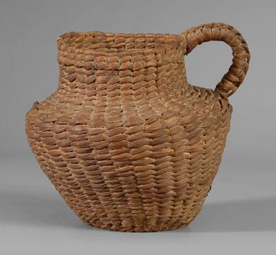 Appraisal: Pitcher-shaped basket ribbed and woven rye foot ring applied handle