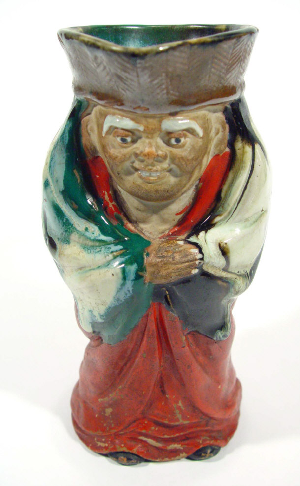 Appraisal: Oriental stoneware Toby jug with red glazed decoration painted character