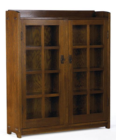 Appraisal: GUSTAV STICKLEY Double-door bookcase with gallery top and three fixed