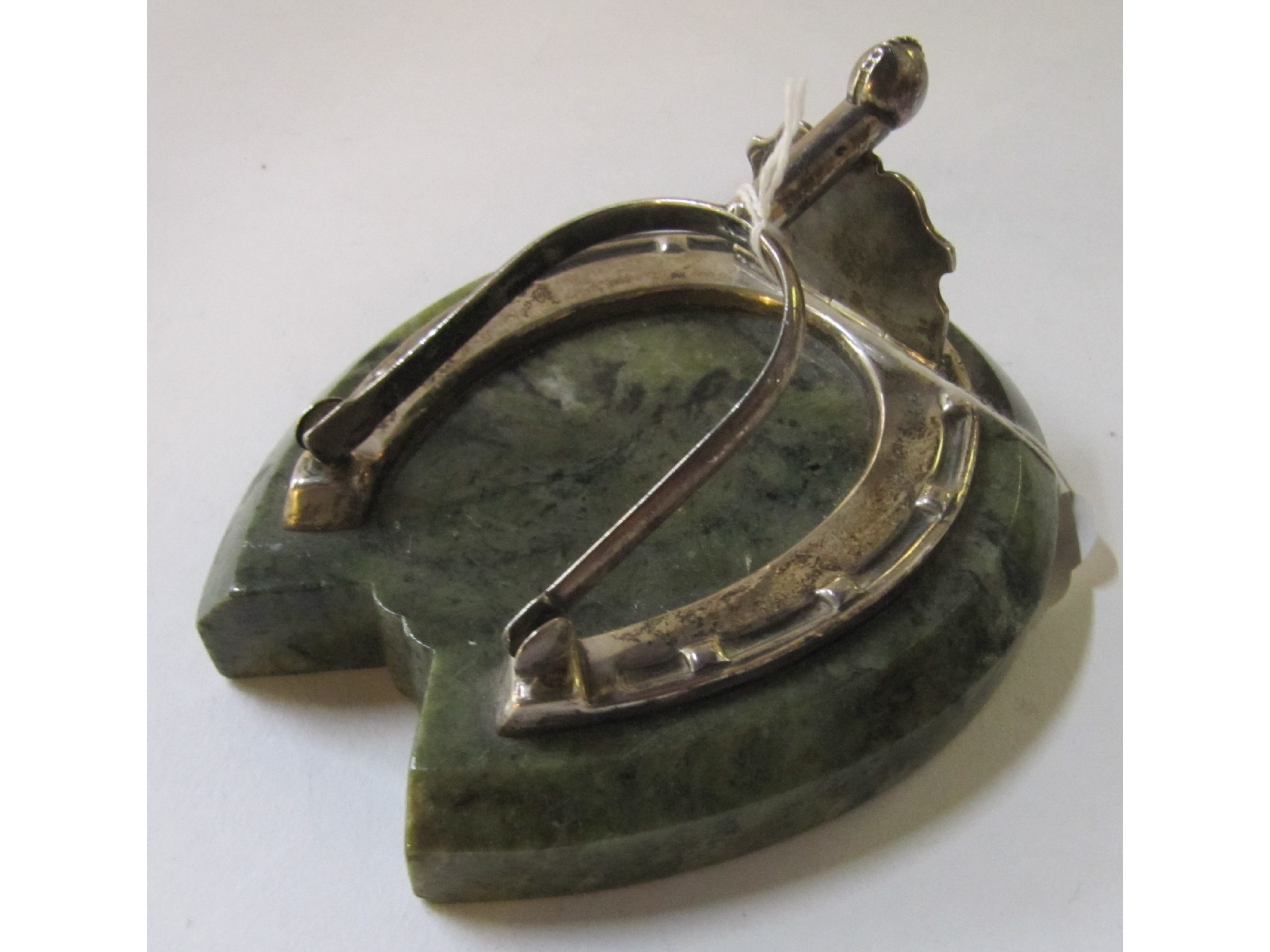 Appraisal: A desk top letter clip modelled as a silver horseshoe