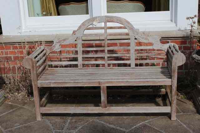 Appraisal: A LUTYENS STYLE TEAK GARDEN SEAT with camel back and