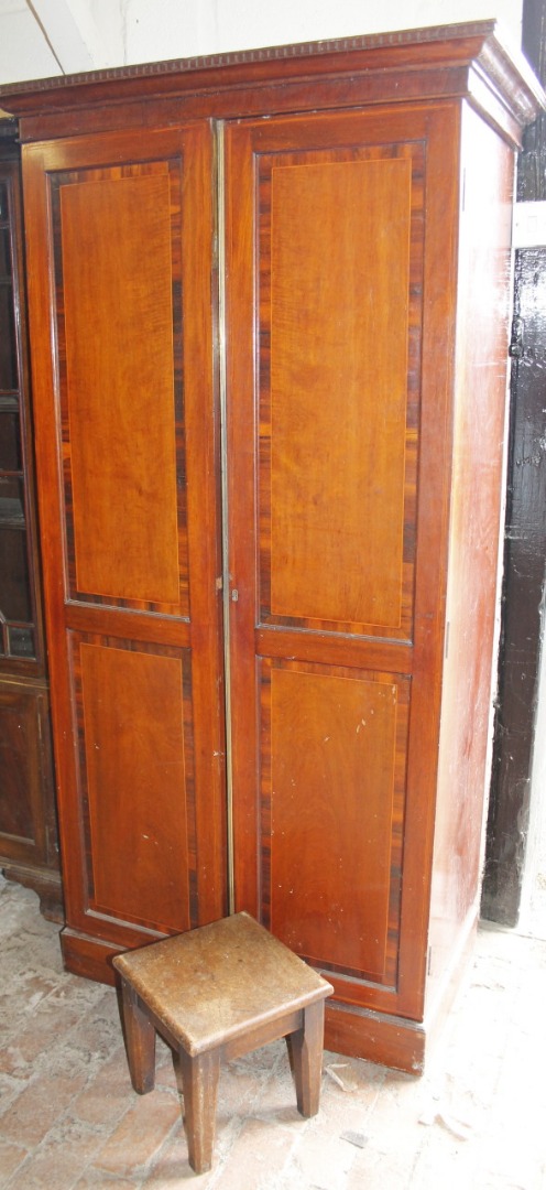 Appraisal: An Edwardian mahogany two door cupboard with overhanging dentil cornice