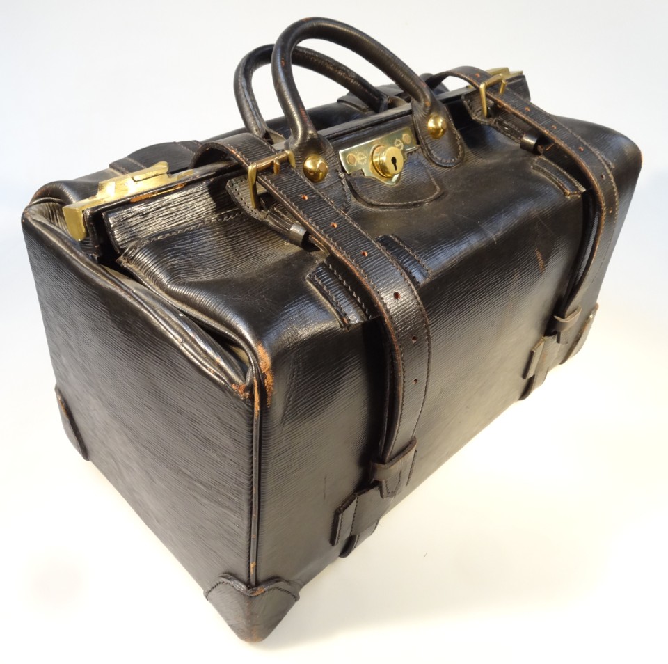 Appraisal: A thC black leather Gladstone bag with brass fittings and