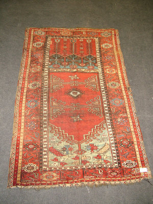 Appraisal: A Caucasian rug the brick red field enclosed by a