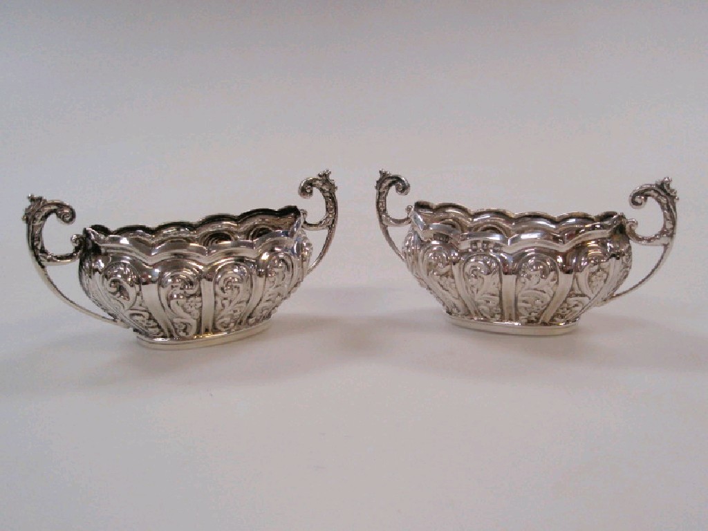 Appraisal: A pair of Victorian silver salts with repouss scrolling decoration