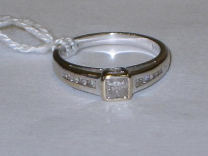 Appraisal: A SOLITAIRE DIAMOND RING in square setting with small diamonds