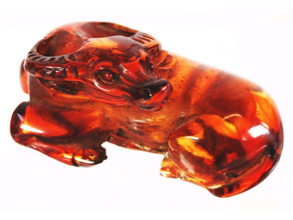 Appraisal: JAPANESE AMBER NETSUKE IN THE FORM OF A RECUMBANT OX