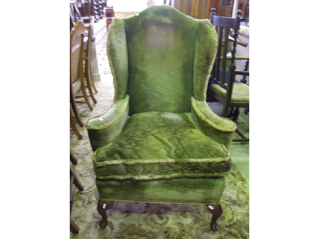 Appraisal: A Georgian style wing chair with shaped arms upholstered finish