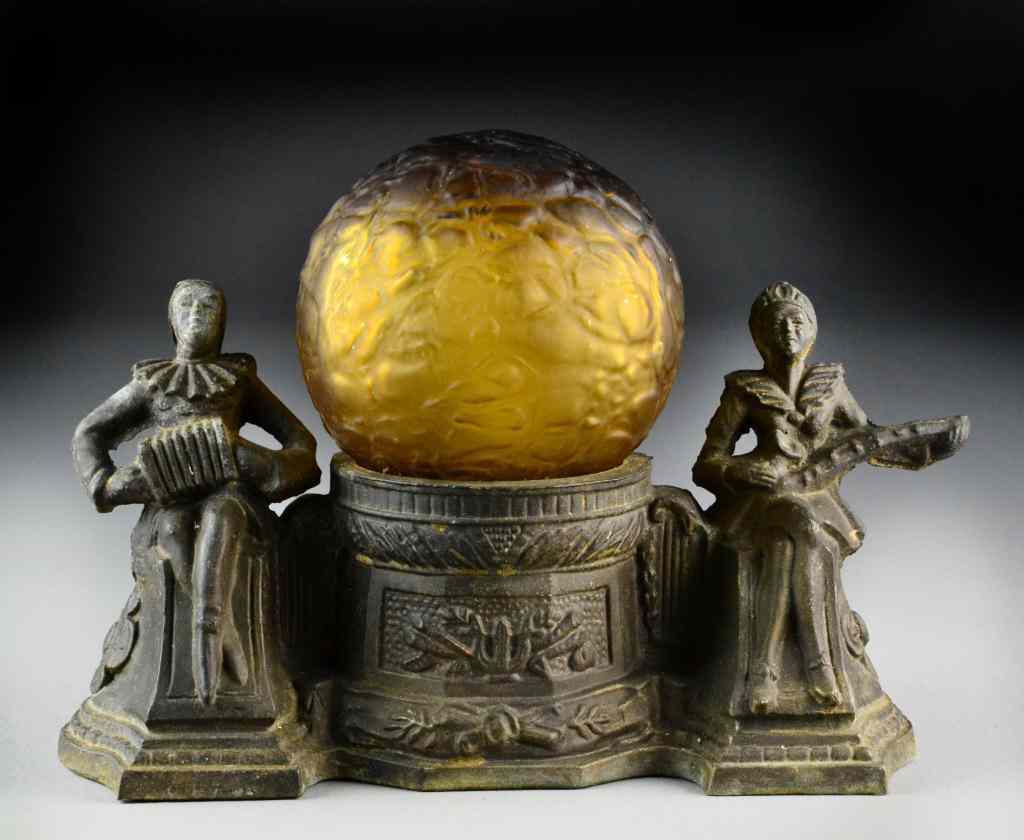 Appraisal: Art Deco Lamp with Amber Glass ShadeDepicting musicians flanking a