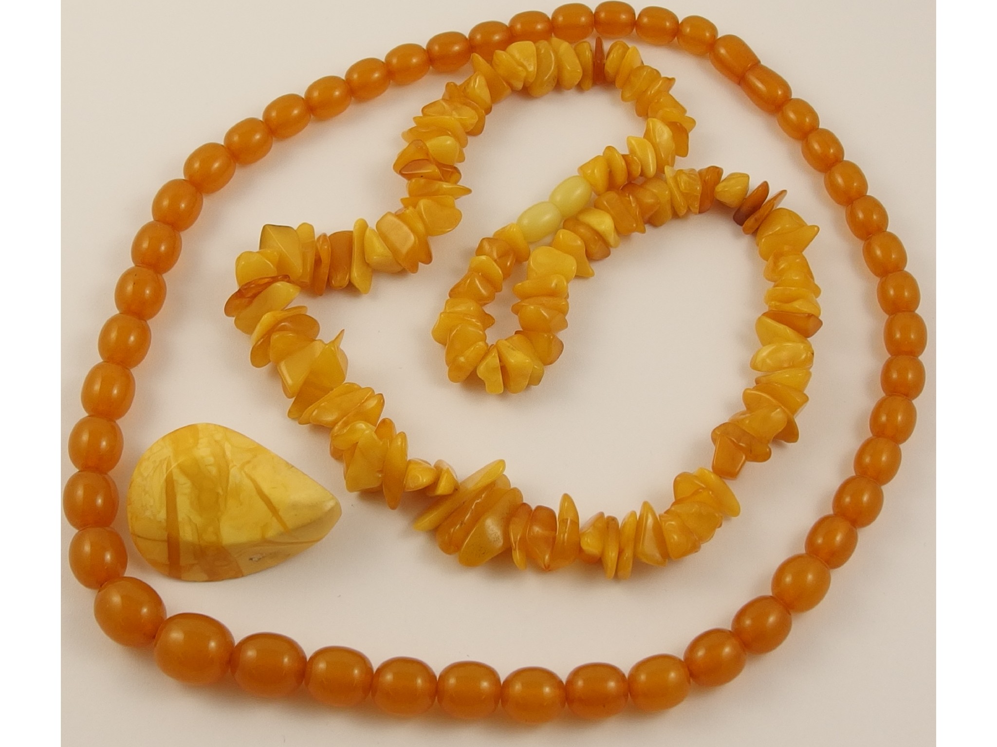 Appraisal: A collection of amber coloured jewellerya yellow amber chip necklace