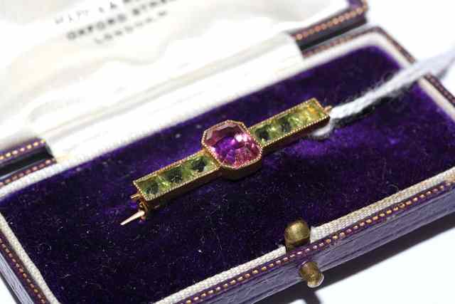 Appraisal: A PINK TOURMALINE AND PERIDOT BAR BROOCH central emerald cut