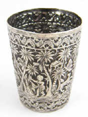 Appraisal: An Eastern white metal tests silver beaker with embossed tropical