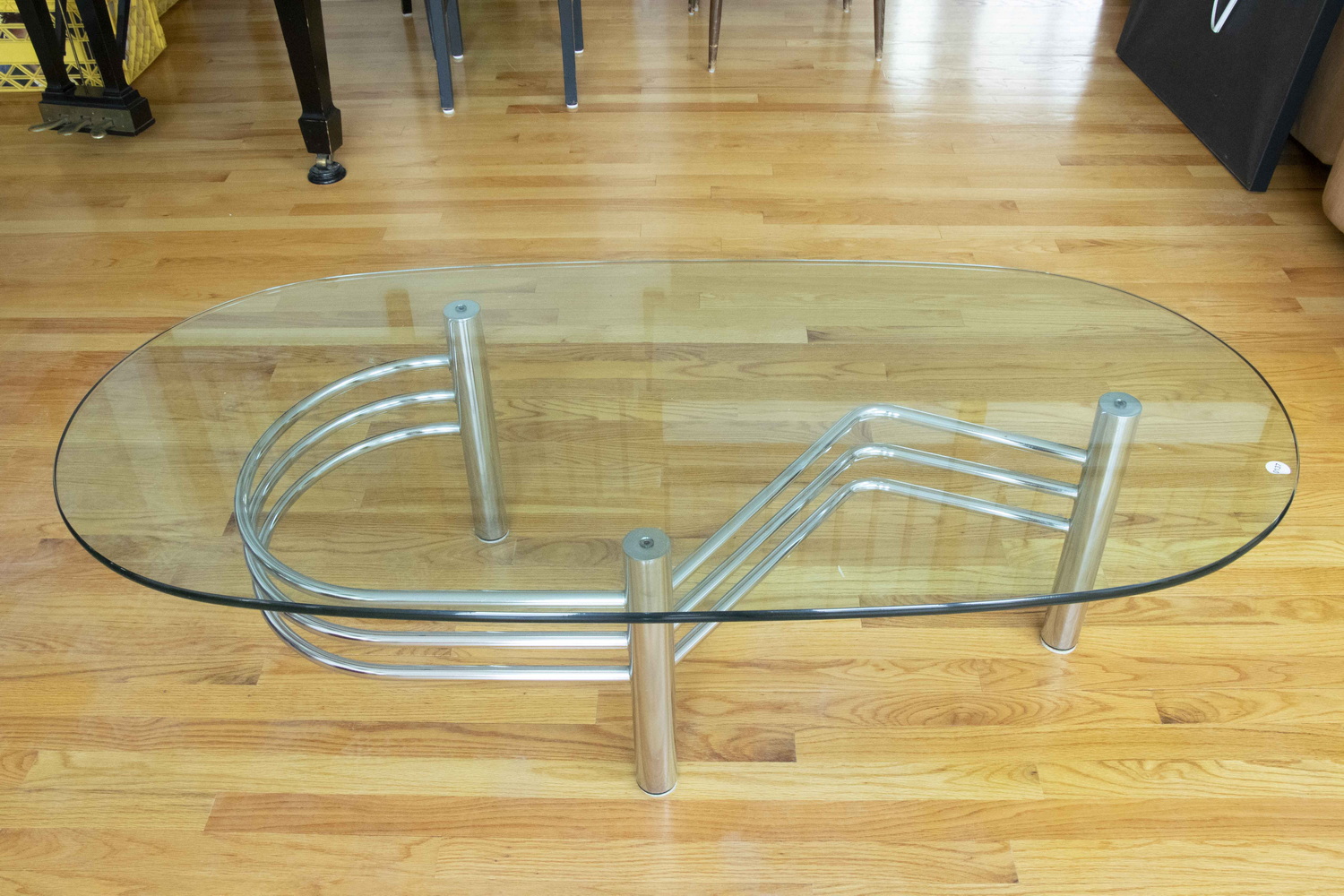 Appraisal: OVAL GLASS-TOP COFFEE TABLE ON CHROME STAND A modern coffee